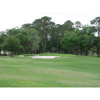 The 18th green at Crescent Pointe Golf Club has bunkers left and a drop-off into trees just about everywhere else.